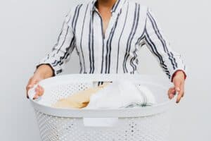 Persoon met wasmand vol met droge, schone was